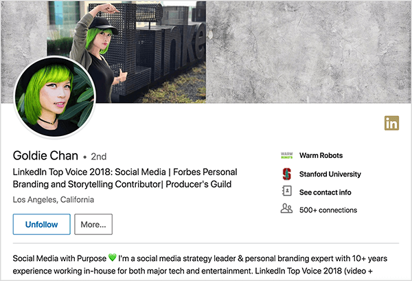 Это скриншот профиля Голди Чан в LinkedIn. Она азиатка с зелеными волосами. На фото в профиле на ней косметика, черное колье-чокер и черная рубашка. Ее слоган гласит: «LinkedIn Top Voice 2018: социальные сети | Автор персонального брендинга и рассказывания историй Forbes | Гильдия продюсеров »