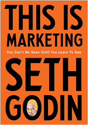Это скриншот обложки книги Сета Година «Это маркетинг». Обложка представляет собой вертикальный прямоугольник с оранжевым фоном и черным текстом. Фотография головы Сета появляется в букве «О» его фамилии.